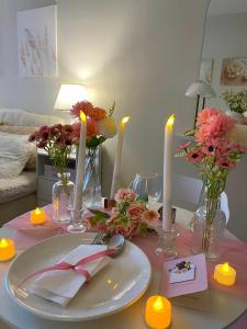 a table with a white plate with candles and flowers at Yahay-living & Condotel in Suba