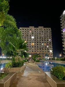 a large building at night with a pool in front of it at Yahay-living & Condotel in Suba +8 photos