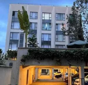 a building with a palm tree in front of it at Bellora Urban Homes in Ongata Rongai 