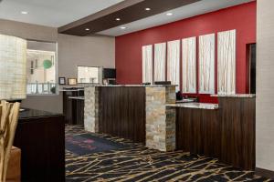 a hotel lobby with a reception desk and red walls at Ramada by Wyndham Grand Forks in Grand Forks