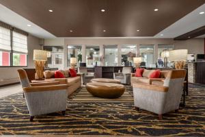a living room with two couches and a table at Ramada by Wyndham Grand Forks in Grand Forks