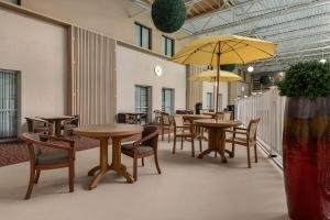 a restaurant with tables and chairs and a yellow umbrella at Ramada by Wyndham Grand Forks in Grand Forks +64 photos