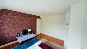 a room with a bed and a purple wall at Welcome Homes! Feels Homes ! in Kidlington
