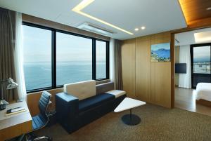 a hotel room with a laptop computer on a couch at Ramada by Wyndham Gangwon Sokcho in Sokcho