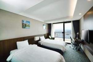 a hotel room with two beds and a balcony at Ramada by Wyndham Gangwon Sokcho in Sokcho +92 photos