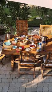 a wooden picnic table with food on it at La Provinciale en Ville in Montélimar