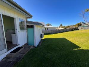 a house with a green lawn next to a house at Beach Break in Tathra