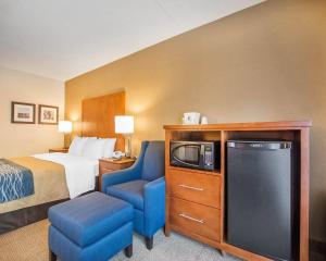 a hotel room with a bed and a tv and a chair at Comfort Inn in Bathurst
