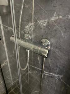 a shower with a metal handle in a bathroom at Hotel Alexander in Mänttä +47 photos