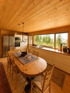 a kitchen and dining room with a wooden table and chairs at Grand Mountain Lodge Filefjell in Tyinkrysset +13 photos