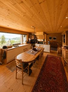 a kitchen and dining room with a wooden table and chairs at Grand Mountain Lodge Filefjell in Tyinkrysset