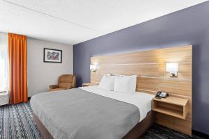 a hotel room with a large bed and a chair at Quality Inn Rochester South in Rochester +44 photos