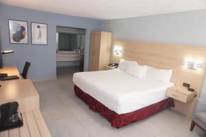a hotel room with a large bed and a bathroom at Quality Inn Piedras Negras in Piedras Negras