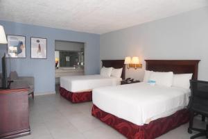 a hotel room with two beds and a television at Quality Inn Piedras Negras in Piedras Negras
