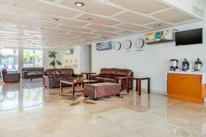 a living room with leather furniture and a flat screen tv at Quality Inn Mazatlan in Mazatlán