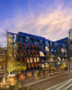 a building with a blue facade on a city street at West Hotel Sydney, Curio Collection by Hilton in Sydney
