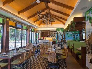 a restaurant with tables and chairs and a chandelier at Katunggan Cove Resort in Nueva Valencia