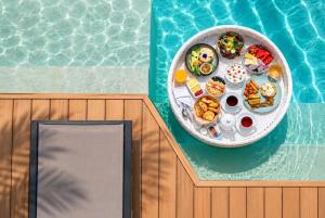 a plate of food on a table next to a pool at Wyndham Grand Nai Harn Beach Phuket in Nai Harn Beach