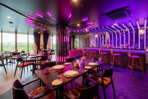 a restaurant with tables and chairs and purple lighting at Wyndham Grand Nai Harn Beach Phuket in Nai Harn Beach +23 photos