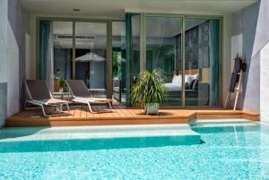 a house with a swimming pool next to a bedroom at Wyndham Grand Nai Harn Beach Phuket in Nai Harn Beach