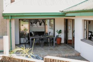 a patio with tables and chairs on a house at De Mist Graskop in Graskop