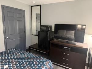 a bedroom with a bed and a dresser and a mirror at Western Motel - Jesup in Jesup