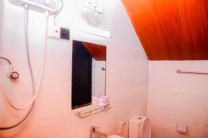 a bathroom with a shower and a toilet and a mirror at Grounder's River Cabin in Nanu Oya +58 photos