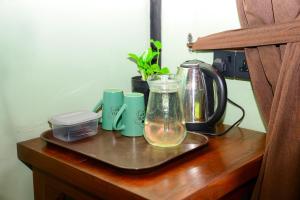 a table with a coffee maker and a tea kettle at Grounder's River Cabin in Nanu Oya