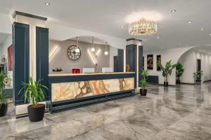 a lobby with a reception desk and potted plants at Ramada Encore by Wyndham Midyat in Midyat +47 photos