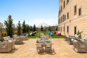 a patio with tables and chairs next to a building at Ramada Encore by Wyndham Midyat in Midyat