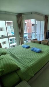 a large green bed with two blue pillows on it at Grandblue condominium 602 in Ban Tha Fat +19 photos
