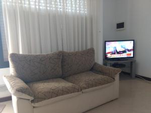 a living room with a couch and a tv at Mein Gästehaus in Gualeguaychú