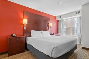 a bedroom with a large bed with an orange wall at MainStay Suites Appleton Airport - Fox River Mall Area in Appleton +46 photos
