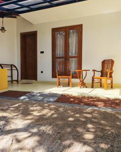 a living room with two chairs and a table at Mogra Bliss in Matara