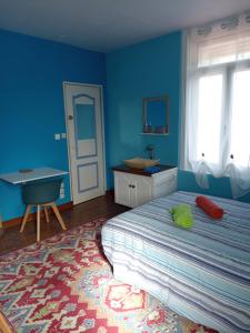 a bedroom with a bed and a blue wall at L'Irisée in Liévin