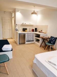 a kitchen and living room with a table and chairs at Aiolos Studios Κythnos in Kithnos