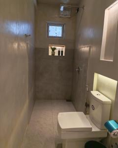 a bathroom with a toilet and a window at Mogra Bliss in Matara