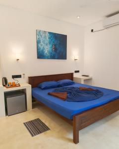 a bedroom with a bed with a blue comforter at Mogra Bliss in Matara
