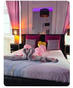 a bed with pink and grey balloons on it at Suite Romantique La Charmante in Villersexel