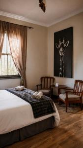 a bedroom with a bed with a giraffe on the wall at De Mist Graskop in Graskop