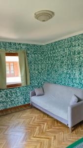 a room with a couch and a green wall at La Tana del Ghiro in Condove