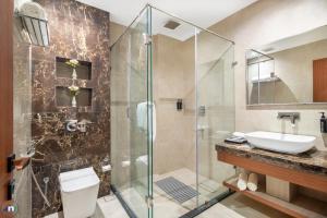 a bathroom with a shower and a toilet and a sink at Northern Residency in Srinagar +30 photos