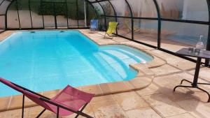 a swimming pool with two chairs and a table and a tablektop at La maison imart in Revel