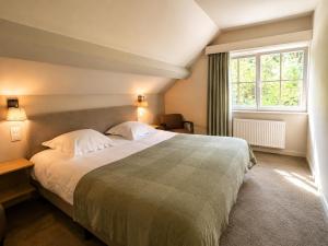 a bedroom with a large bed and a window at La Barrière de Transinne in Libin
