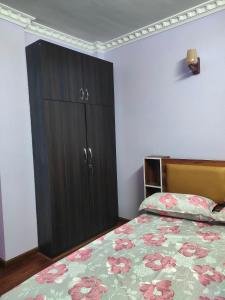 a bedroom with a bed and a black cabinet at Durbar Home in Tribhuwan Airport