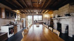a large kitchen with chairs and a fireplace at Hank's Folly in Wapengo +30 photos