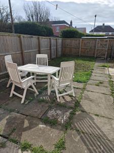 two white chairs and a table in a backyard at Pet-Friendly Home with Secure Garden nr Beamish in Birtley