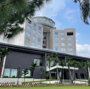 a large building with palm trees in front of it at Holiday Home Ranchi in Rānchī