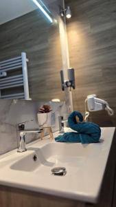 a bathroom sink with a blue towel on it at Suite Romantique La Charmante in Villersexel +16 photos