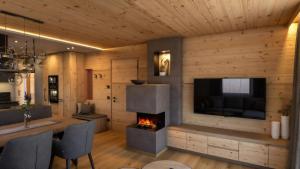 a living room with a fireplace and a television at Tlisöra Speckstube in Frena